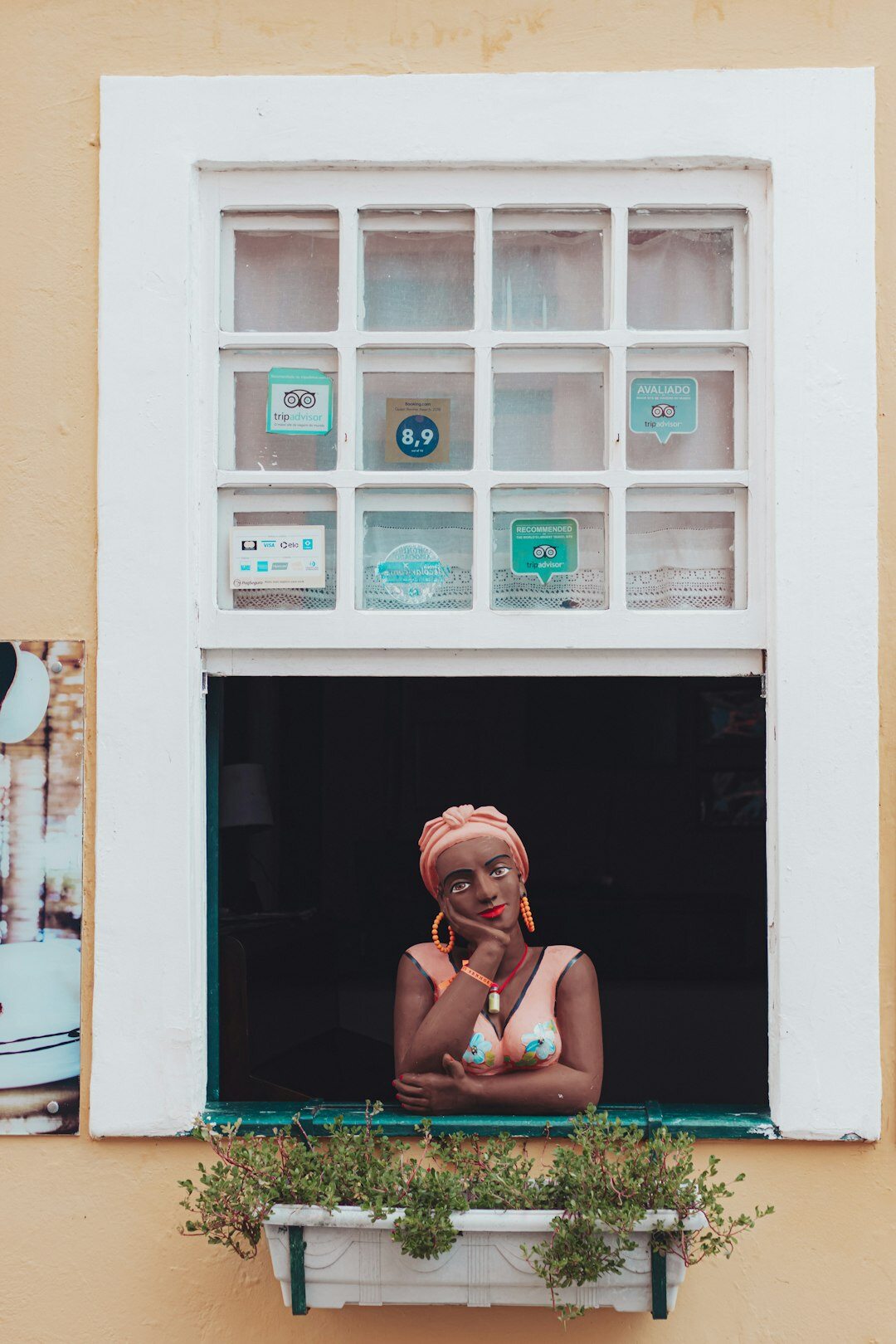 Brazilian woman writing thoughtfully in a journal by a window